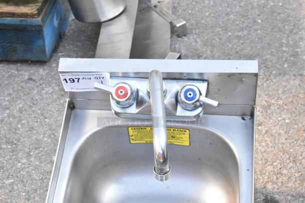 Commercial single bay stainless steel sink with dual faucets, no legs, includes caution label on disposal of bleach. Auction tag 197.