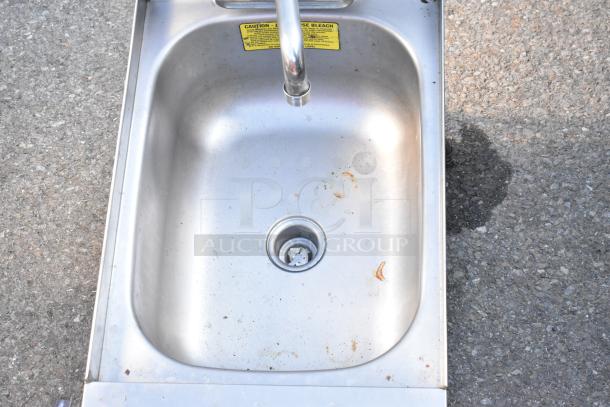 Commercial single bay stainless steel sink, no legs, with drain; minor stains present, caution label visible.