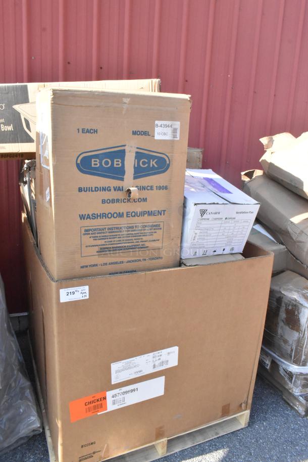 Boxes containing new Bobrick dispenser and Canarm ventilation fan. Some visible wear on packaging. Includes multiple items.