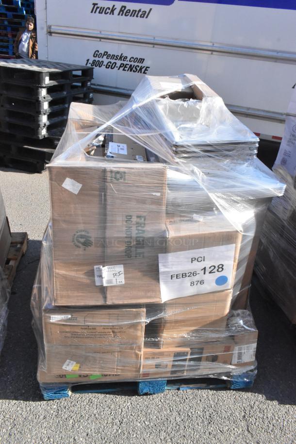 Paletted stack of 28 new scratch and dent items including pasta bowls, shelf, table, and pizza pan; labeled "FEB26-128."