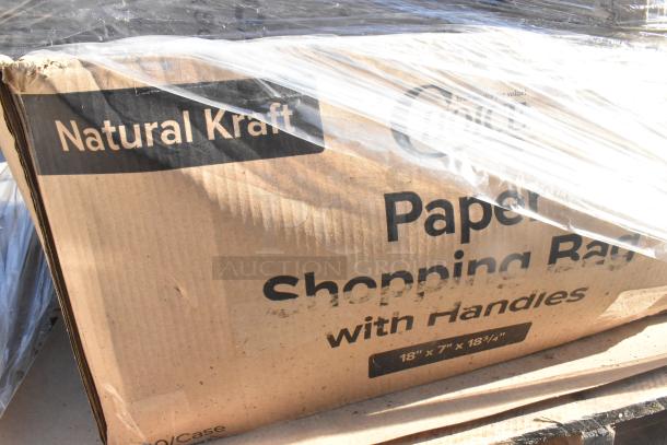Cardboard box labeled "Natural Kraft Paper Shopping Bags with Handles," showing minor damage. Dimensions: 18"x7"x18.75".