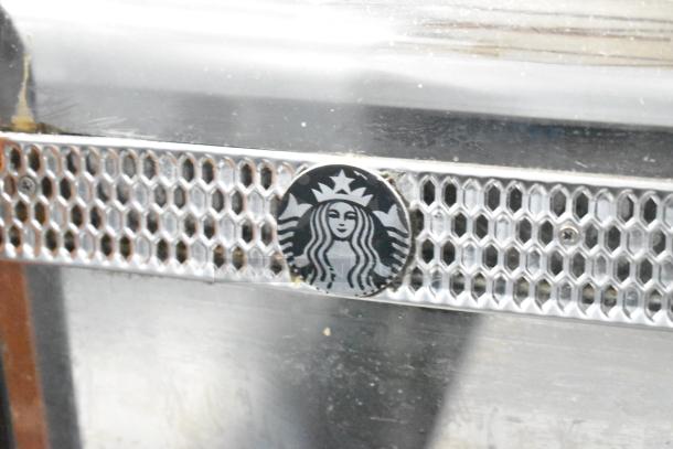 Thermoplan Mastrena espresso machine, stainless steel detail with logo. Commercial use, 250 volts, countertop model.