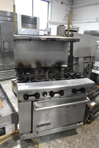 American Range 6-burner gas stove with oven, overshelf, backsplash, on casters. Shows signs of use; ideal for commercial kitchens.