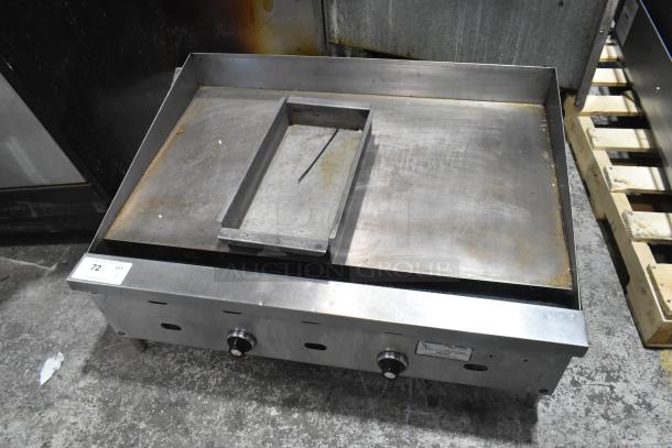 Commercial countertop gas-powered flat top griddle with dual controls, used condition, minor surface wear visible.