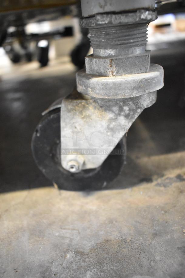 Close-up of a caster wheel on the Electro Freeze 30T-RMT-137 commercial soft serve machine, showing wear and metal components.