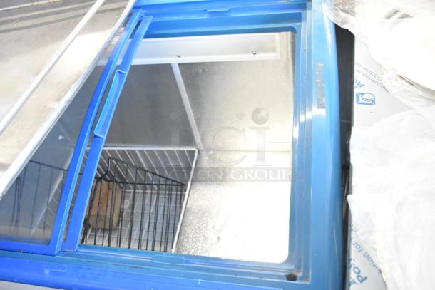 XS-208 chest freezer merchandiser with commercial casters, blue frame, sliding glass lid, and interior basket. 115 volts, 1 phase.