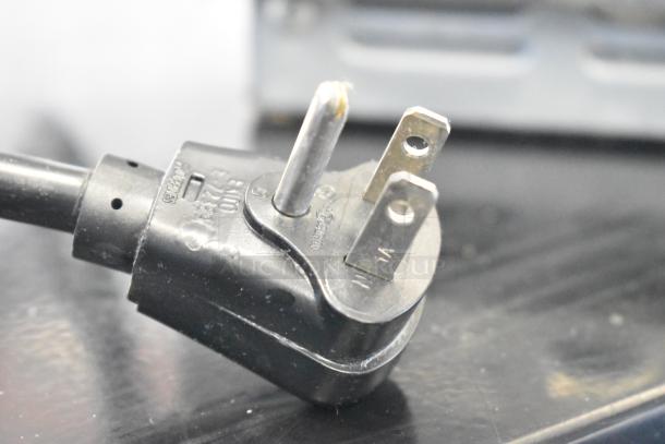 Close-up view of a power plug for a 2021 Amana RCS10TS Commercial Microwave Oven, 120 Volts, 1 Phase.