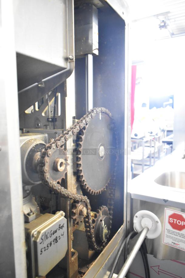 JBT 2ND-GEN-MFJ-HE citrus juicer gearbox view, showing chain mechanism and serial number 5255824. Commercial-grade condition.