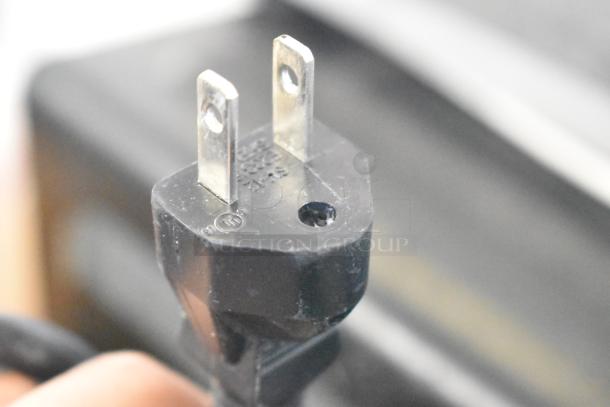 Close-up of a power plug for a Chic Chefs CC-050S single burner induction range, showing two prongs.