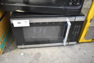 Mainstays HB84619315-01 countertop microwave oven, black with silver accents, 120 volts, digital controls, used condition.