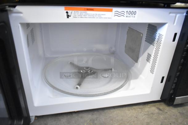 Mainstays HB84619315-01 countertop microwave, 1000 watts, showing interior with turntable. Tags indicate 120 volts, 1 phase.