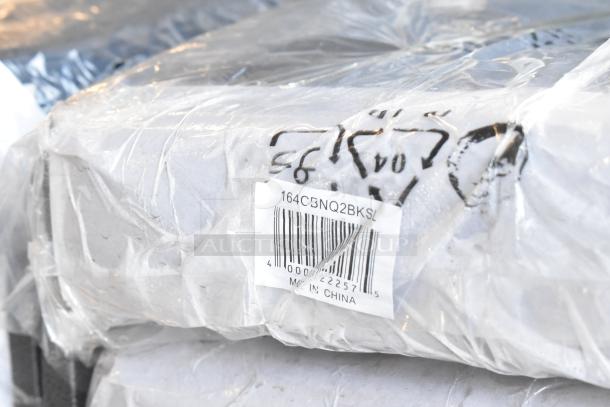 Stack of wrapped Lancaster Table & Seating banquet chairs with visible label "164CBNQ2BKSL." Black with silver vein frame.