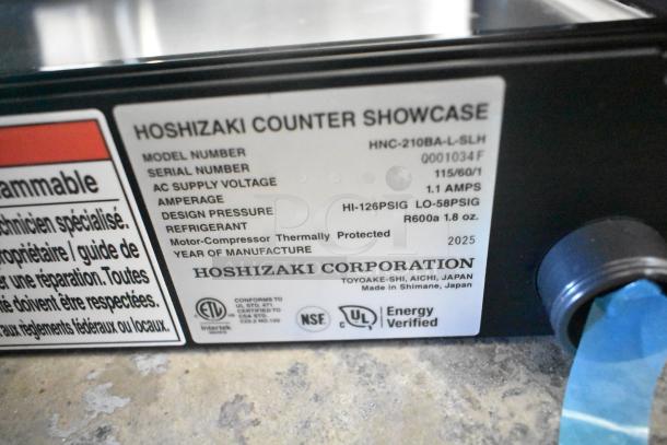 Brand new 2025 Hoshizaki HNC-210BA-L-SLH sushi display case label, showing model, voltage, amperage, refrigerant, and certifications.