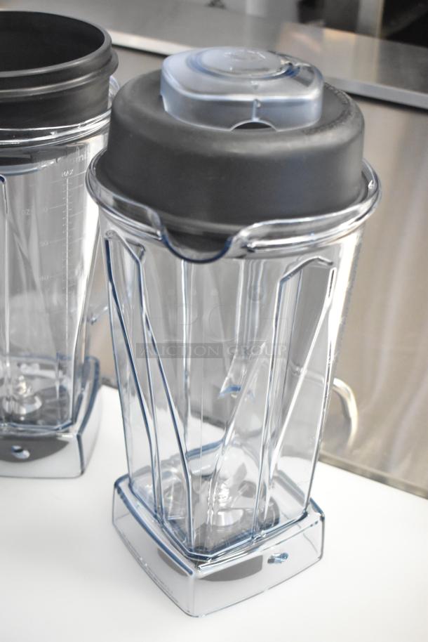 Two brand new scratch and dent clear poly blender pitchers with black lids. Durable and functional design.