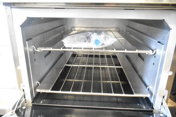 BRAND NEW Vulcan 24S-4BN commercial range with 4 burners, 24" oven, 143,000 BTU. Interior view showing oven racks and packaging.