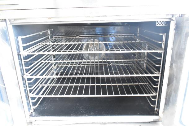 Southbend G Series commercial convection oven interior with view-through doors, thermostatic controls, stainless steel racks, on casters.