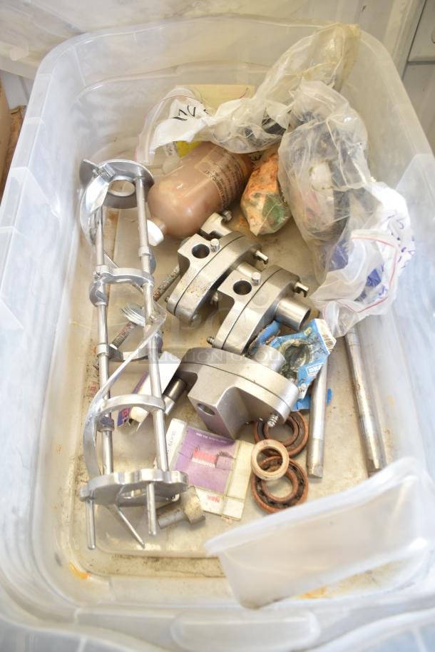 Two bins of various Taylor ice cream machine parts, including metal augers, clamps, and miscellaneous components in used condition.