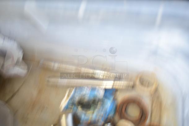Blurry image showing bins with Taylor ice cream machine parts and augers. Contents unclear due to image quality.