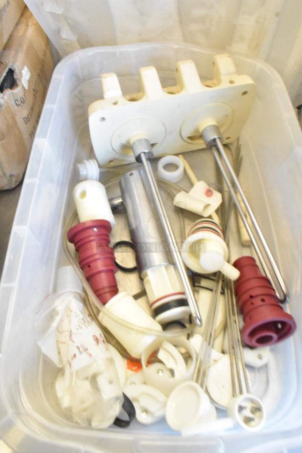 Two bins containing various Taylor ice cream machine parts, including augers, rods, and seals, in used condition.