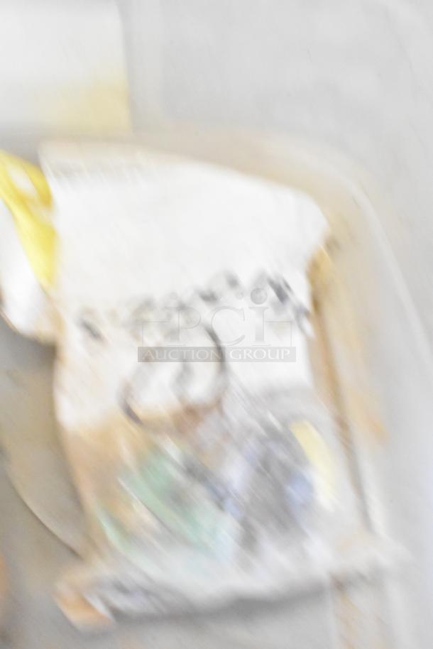 Blurred image of bins containing various Taylor ice cream machine parts, including augers and assorted components.