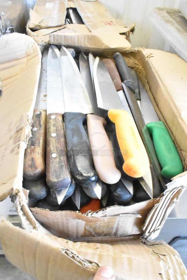 Box of 100 sharpened stainless steel knives including various chef knives with assorted colored handles. Carton is worn.