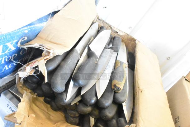 Box of 60 sharpened stainless steel knives, including chef knives, with black handles. Worn cardboard packaging.
