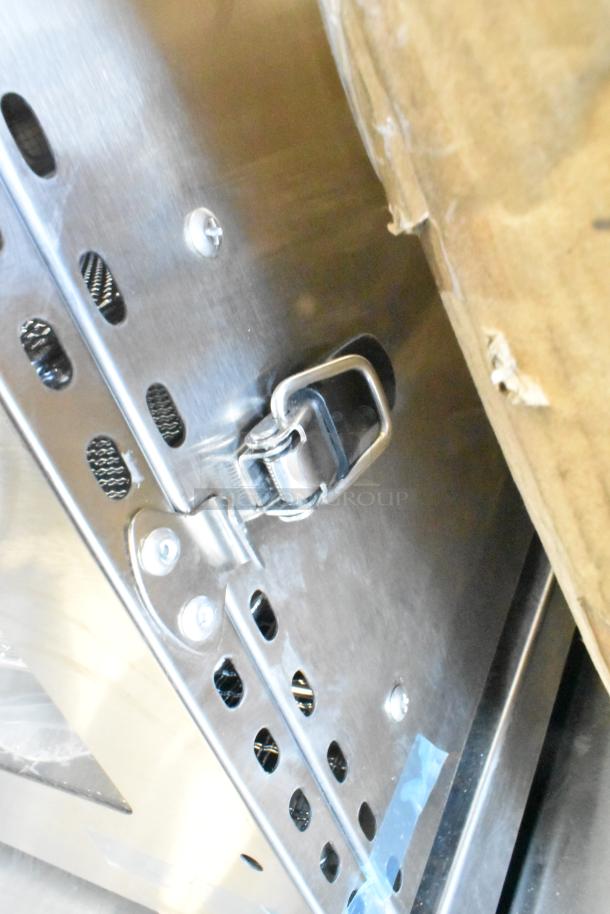 Stainless steel latch detail on Avantco 177LT06A 6 Tray Food Dehydrator, showing vent holes and scratch marks.