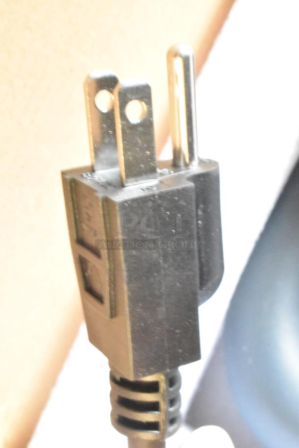 Close-up of a three-pronged plug from a 2024 AvaMix Heavy-Duty Variable Speed Immersion Blender, new but with scratches.