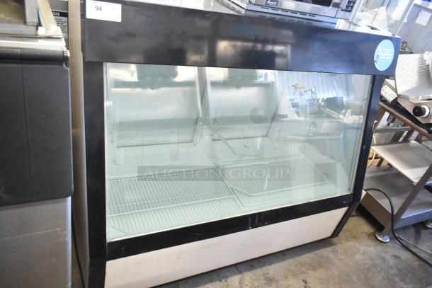 Commercial floor-style deli display case, glass front, 208 volts, 1 phase, metal shelving, black and white exterior, good condition.