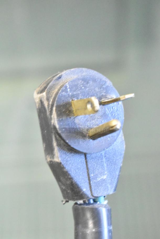 Plug for Commercial Floor Style Deli Display Case Merchandiser, 208 Volts, 1 Phase; shows standard prongs and wear.