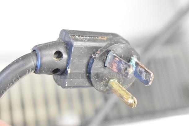 Close-up of a worn electrical plug for the True TSSU-48-12 commercial prep table, showing oxidation on prongs.