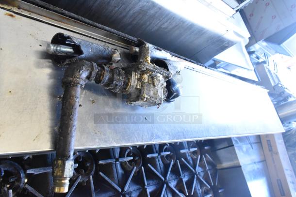 Garland SunFire 10 burner range, commercial gas, with 2 ovens, overshelf, backsplash, visible wear and grease on components.