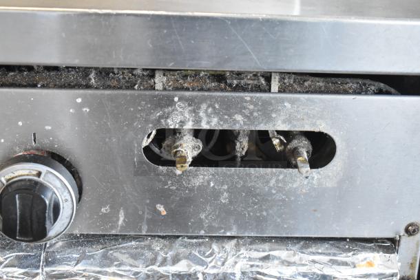 Garland SunFire commercial gas range detail, showing an aged control panel with a visible dial, indicating used condition.