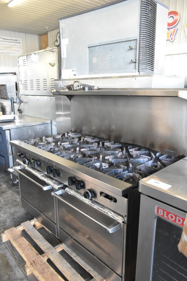 Garland SunFire commercial gas range with 10 burners, dual ovens, over shelf, and backsplash. Visible wear on surfaces.