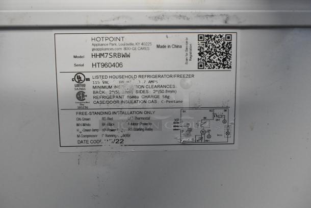 Hotpoint HHM7SRBWW chest freezer label displaying model, voltage, refrigerant, and installation information.