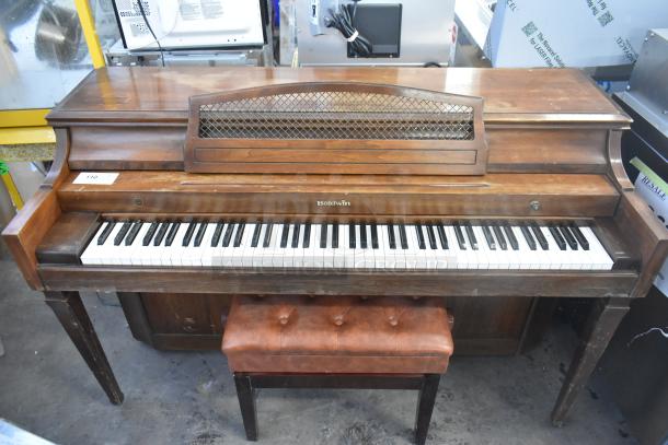 Baldwin piano with bench, features classic wooden design, visible wear, and functional keys, ideal for music enthusiasts.