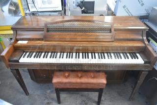 Baldwin piano with bench, features classic wooden design, visible wear, and functional keys, ideal for music enthusiasts.