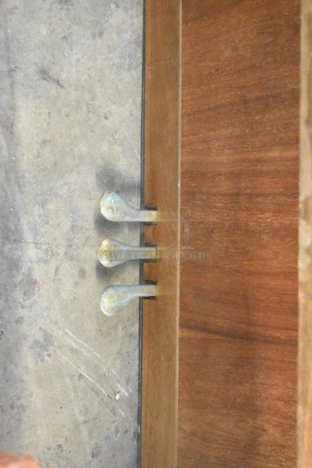 Baldwin piano pedals on hardwood floor. Visible wear indicates vintage condition. Piano bench included.