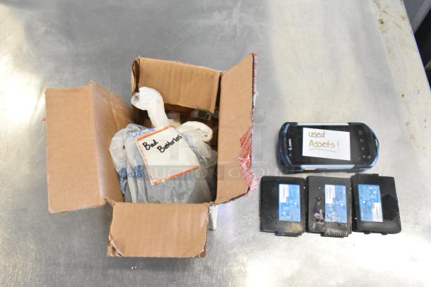 Lot with Zebra unit, labeled "used assets," and three batteries. Includes a box marked "bad batteries." Fair condition.