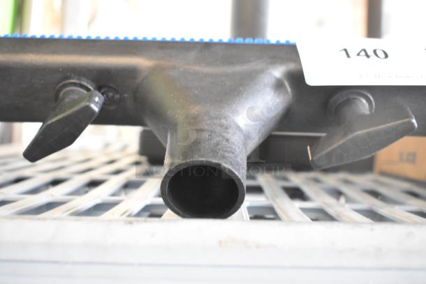 Brand new vacuum attachment with minor scratches, black plastic, dual side levers, labeled "140." Ideal for versatile cleaning.