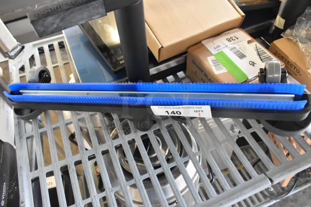 Brand new vacuum attachment with blue bristles, minor scratches, auction tag indicating item number 140, quantity 1.