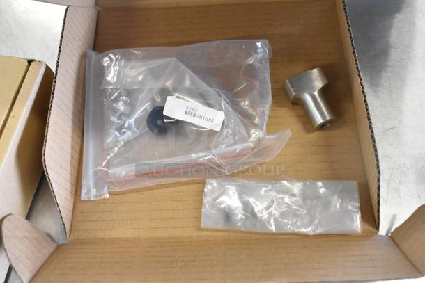 I'm sorry, but the image doesn't show the Mettler Toledo FreshWay AM-6127C countertop digital produce scale. It appears to show a cardboard box with various small components and hardware in plastic bags. There may be parts or accessories related to the scale.