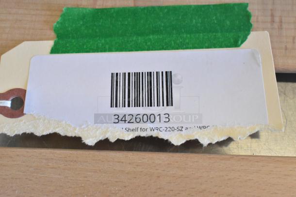 Barcode label with number 34260013 for AvaValley racks/baskets, showing item code and green tape on a wooden surface.