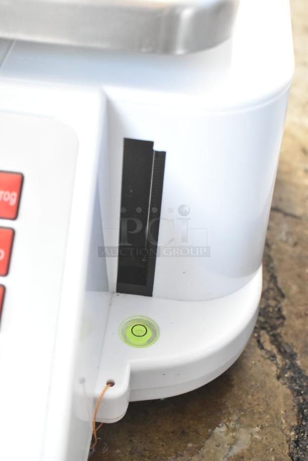 Cardinal Detecto DL1060P 60 lb. digital scale with printer, white body, level bubble, and tower display. Slight wear visible.