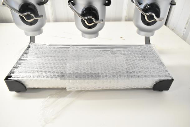 IDM countertop 3-well dry goods dispenser, metallic finish, pristine condition, protective bubble wrap visible.