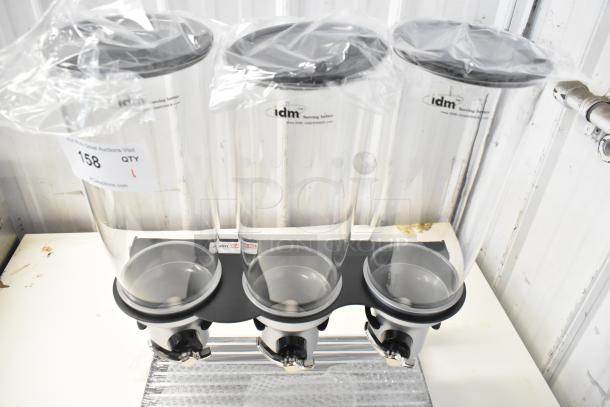 IDM Countertop 3 Well Dry Goods Dispenser, clear plastic with black lids, new condition, branded labels visible.
