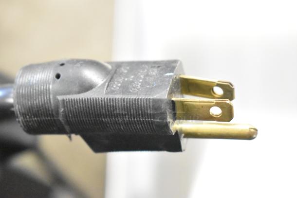 Close-up of the power plug for the H&K 52473-1 Stainless Steel Commercial French Fry Freezer, showing prongs and black casing.