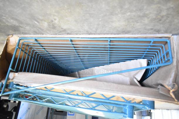 Seven various items including four green finish brackets and three Metro green finish wire shelves in a cardboard box.