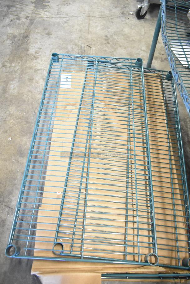 Green Metro wire shelves and brackets, including GS1836K3 grid shelf, in used condition on a concrete floor.