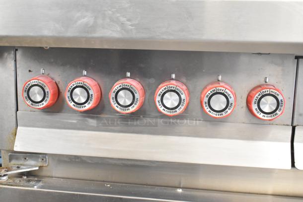 Lang RTI36E electric 6-burner induction range control panel, featuring 6 red knobs marked with heat settings from low to high.